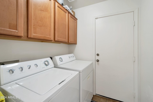 clothes washing area with washing machine and clothes dryer and cabinet space