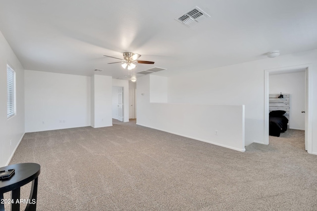 spare room featuring light carpet, visible vents, and a ceiling fan