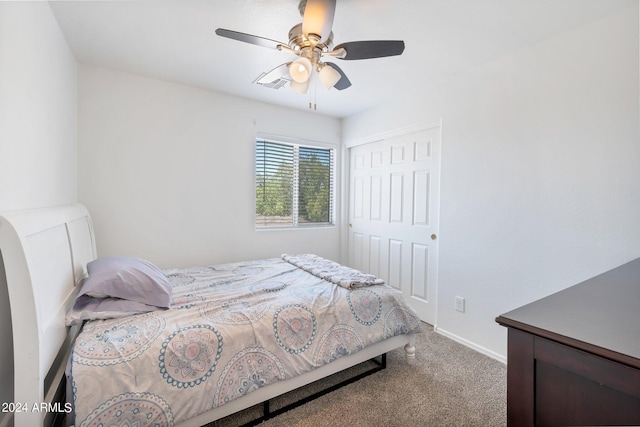 carpeted bedroom featuring a closet, ceiling fan, and baseboards