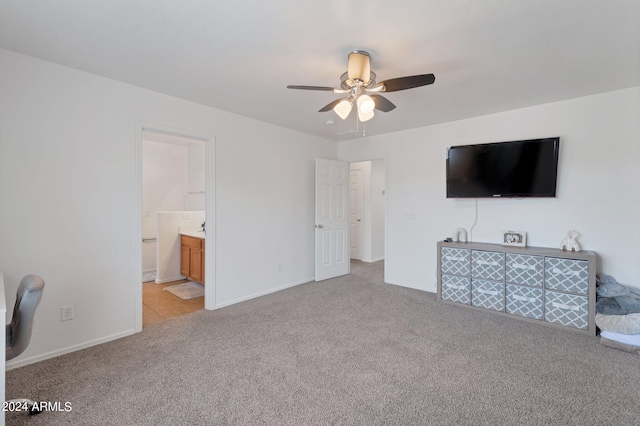 unfurnished bedroom with ensuite bathroom, baseboards, a ceiling fan, and light colored carpet