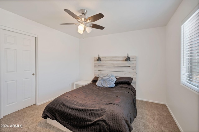 bedroom with light carpet, a ceiling fan, and baseboards