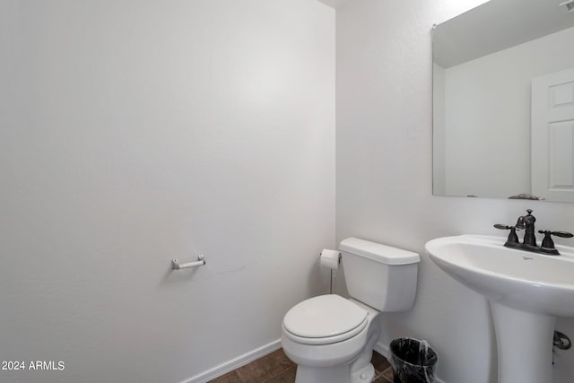 bathroom with tile patterned flooring, a sink, toilet, and baseboards