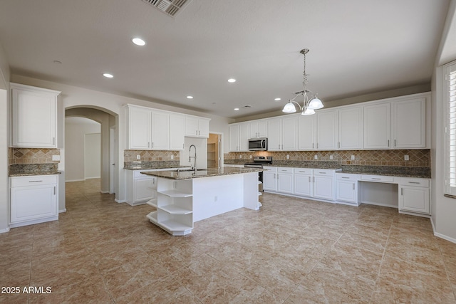 kitchen featuring white cabinets, pendant lighting, an island with sink, and stainless steel appliances