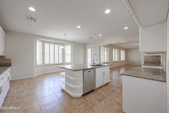 kitchen with dishwasher, backsplash, white cabinets, and an island with sink