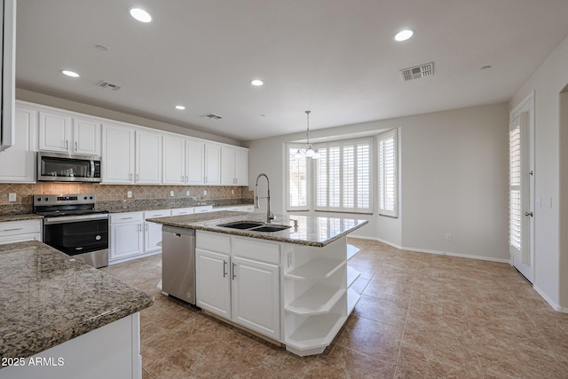 kitchen featuring stainless steel appliances, white cabinetry, a center island with sink, and sink