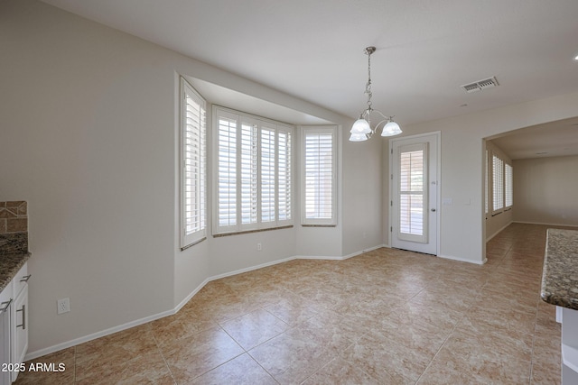 unfurnished dining area with light tile patterned flooring and an inviting chandelier