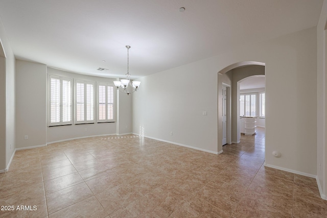 empty room featuring light tile patterned flooring and an inviting chandelier