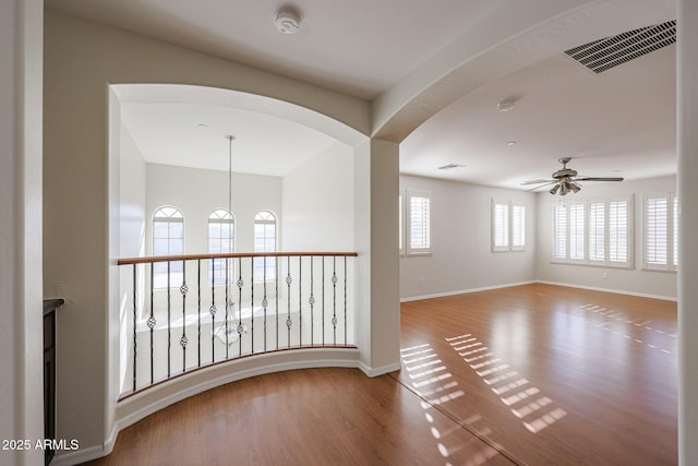 empty room with ceiling fan and wood-type flooring