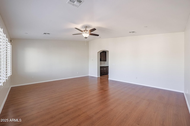 spare room with dark hardwood / wood-style flooring and ceiling fan