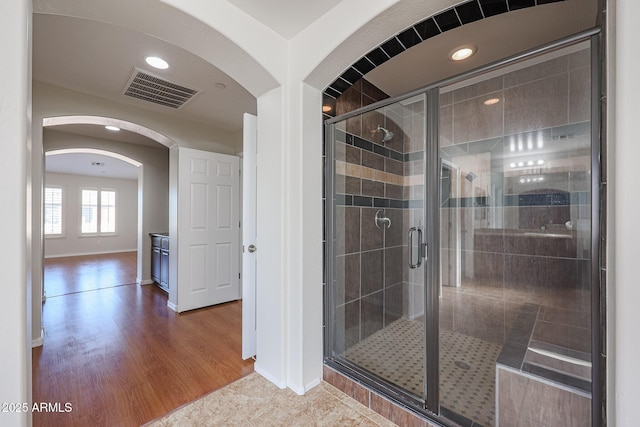 bathroom with an enclosed shower and wood-type flooring