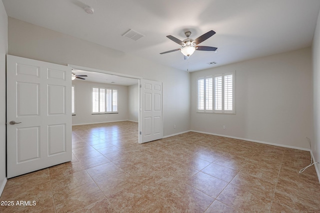 tiled spare room with a wealth of natural light and ceiling fan