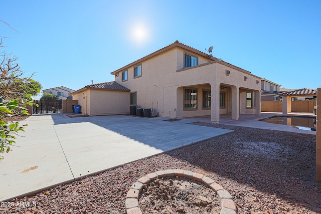 back of property with central air condition unit and a patio area