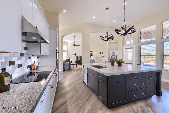 kitchen with white cabinetry, decorative light fixtures, sink, light hardwood / wood-style floors, and black electric cooktop