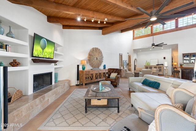5540 E Mercer Ln, Scottsdale, AZ 85254 - living room with a wooden ceiling with exposed beams, ceiling fan, a towering ceiling, and a tiled fireplace
