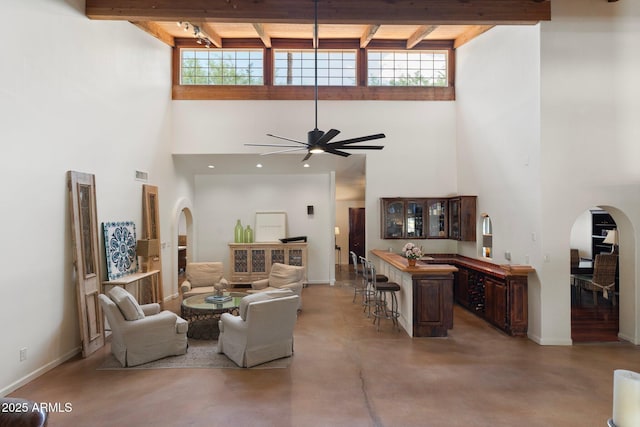 5540 E Mercer Ln, Scottsdale, AZ 85254 - living area with arched walkways, a towering ceiling, concrete floors, ceiling fan, and beamed ceiling