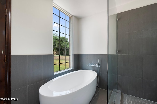 5540 E Mercer Ln, Scottsdale, AZ 85254 - bathroom featuring tile walls, a soaking tub, tile patterned flooring, a wainscoted wall, and a tile shower