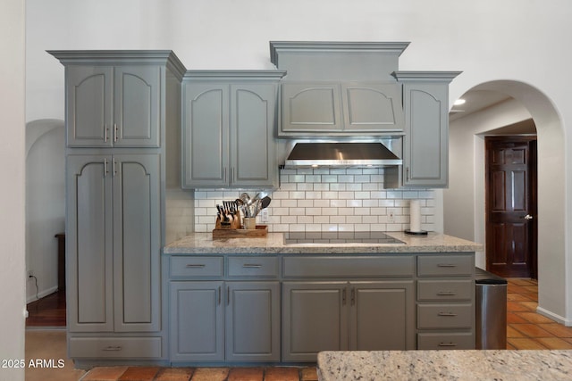 5540 E Mercer Ln, Scottsdale, AZ 85254 - kitchen with black electric cooktop, extractor fan, arched walkways, and decorative backsplash