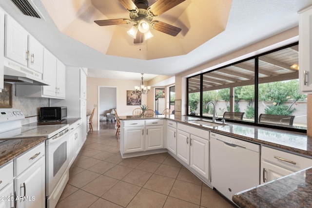 kitchen with sink, white appliances, white cabinetry, kitchen peninsula, and a raised ceiling