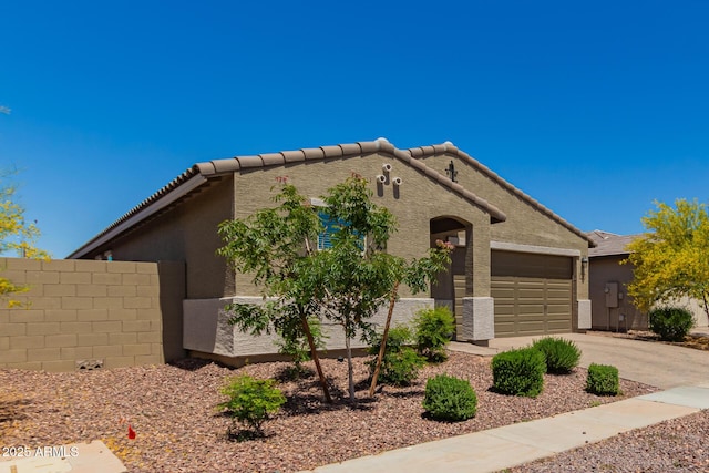 17344 W Red Fox Rd, Surprise, AZ 85387 - view of front of house featuring an attached garage, concrete driveway, stucco siding, and fence