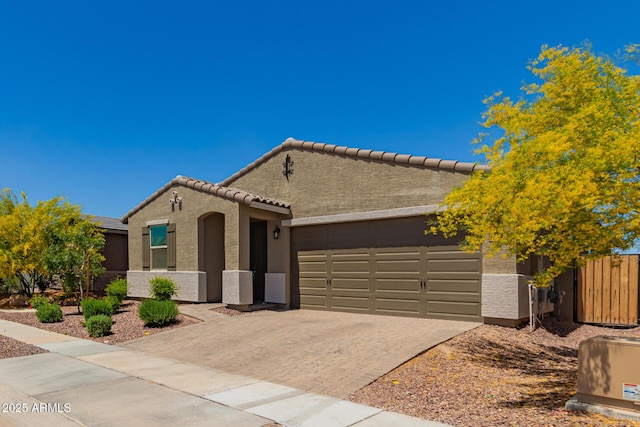 17344 W Red Fox Rd, Surprise, AZ 85387 - view of front of house with fence, a tile roof, a garage, stucco siding, and decorative driveway