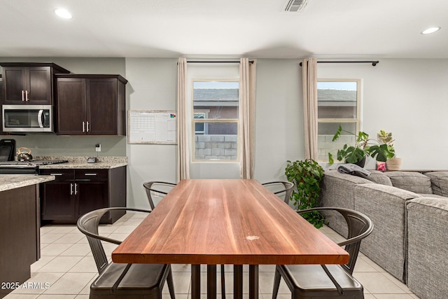17344 W Red Fox Rd, Surprise, AZ 85387 - kitchen featuring stainless steel microwave, light tile patterned floors, a wealth of natural light, and dark brown cabinets