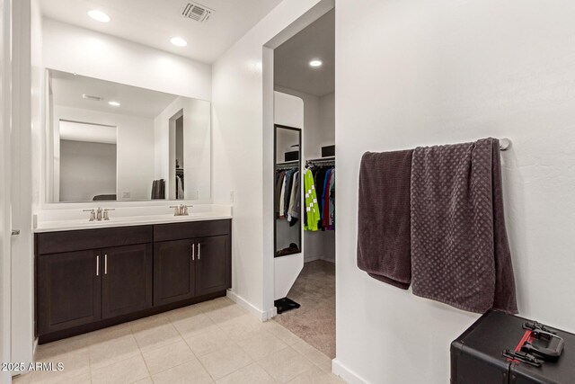 17344 W Red Fox Rd, Surprise, AZ 85387 - bathroom featuring visible vents, tile patterned flooring, double vanity, a walk in closet, and a sink