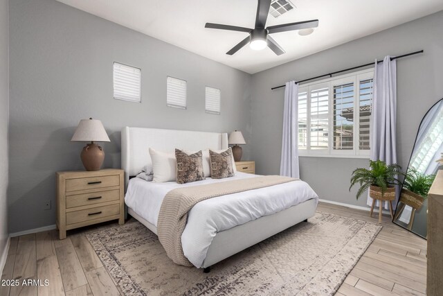 bedroom featuring a ceiling fan, baseboards, visible vents, and light wood-type flooring