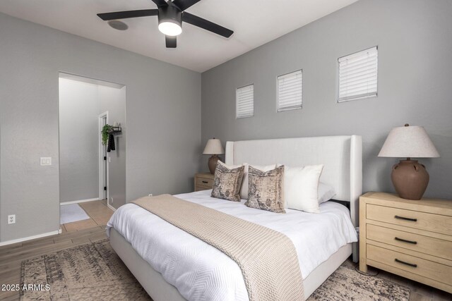 bedroom with wood finished floors, baseboards, and ceiling fan