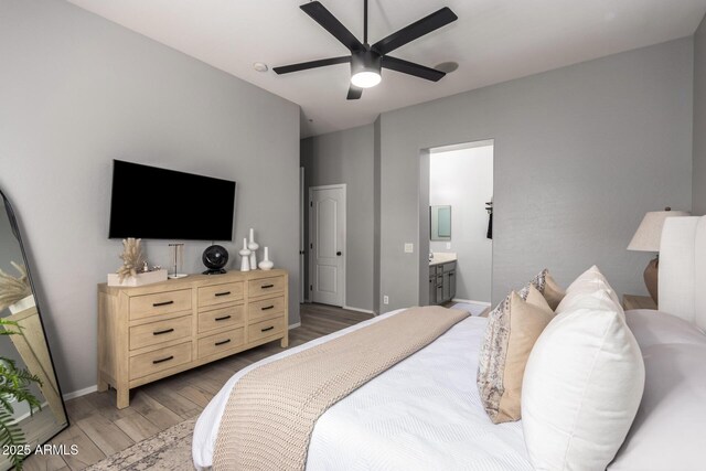 bedroom featuring light wood-type flooring, baseboards, connected bathroom, and a ceiling fan