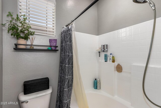 full bathroom featuring toilet, a textured wall, and shower / bath combo with shower curtain