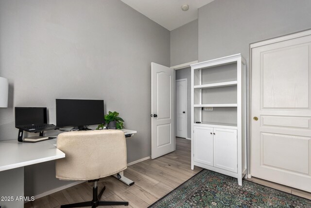 office area featuring light wood-type flooring and baseboards