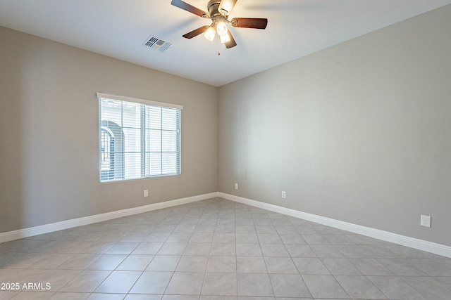 spare room featuring baseboards, visible vents, and a ceiling fan