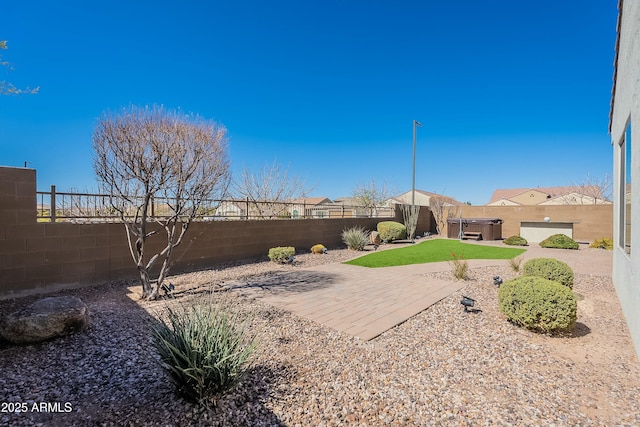 view of yard with a patio area, a hot tub, and a fenced backyard