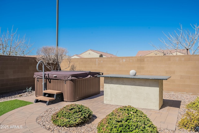 view of patio featuring a fenced backyard and a hot tub