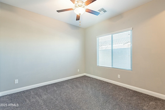 carpeted spare room featuring a ceiling fan, visible vents, and baseboards