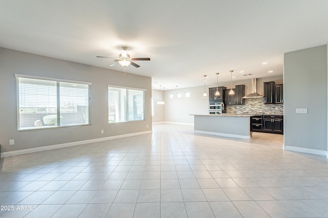 unfurnished living room featuring light tile patterned flooring, ceiling fan, and baseboards