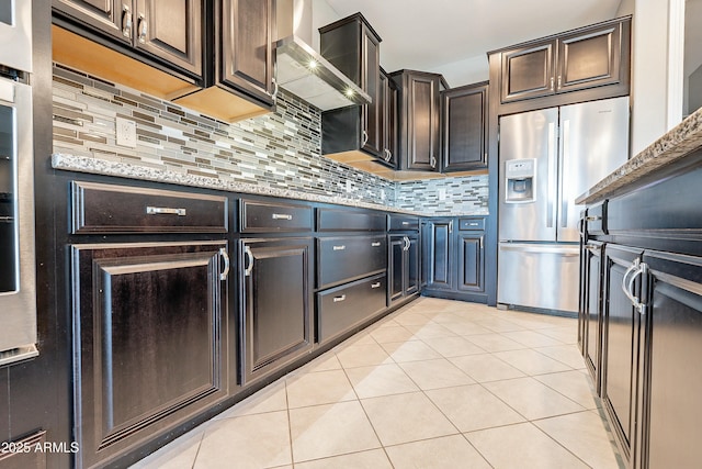 kitchen with light tile patterned floors, stainless steel refrigerator with ice dispenser, decorative backsplash, and light stone countertops