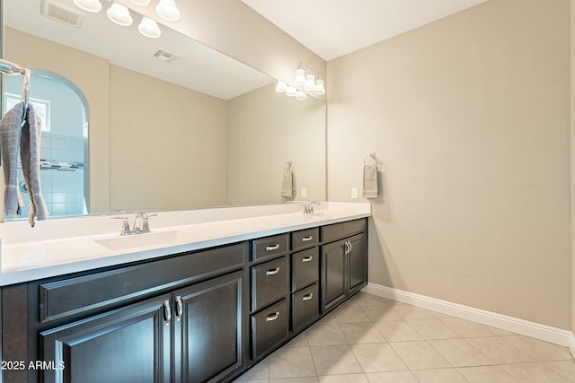 bathroom with tile patterned flooring, a sink, visible vents, baseboards, and double vanity