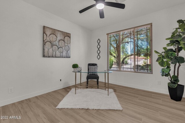 living area with ceiling fan and light hardwood / wood-style flooring