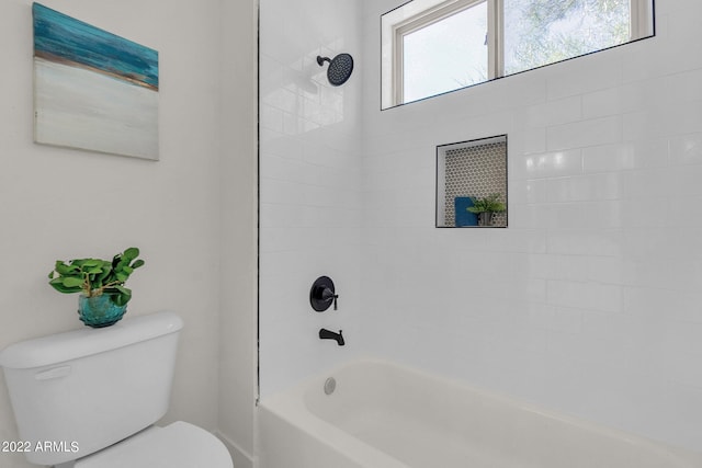 bathroom featuring tiled shower / bath combo and toilet