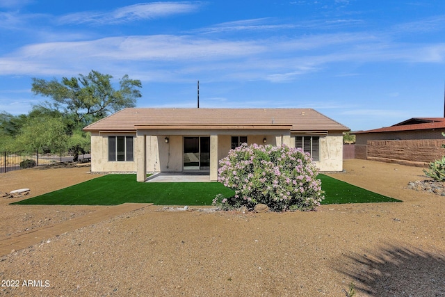 back of house featuring a lawn and a patio