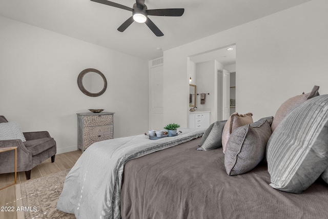 bedroom with light hardwood / wood-style floors, ensuite bath, and ceiling fan