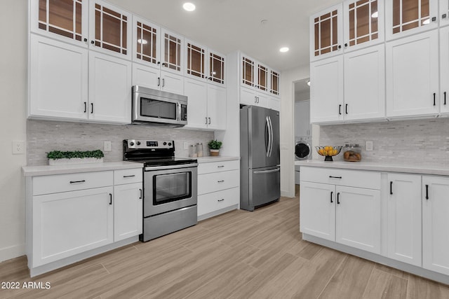 kitchen featuring tasteful backsplash, white cabinetry, and appliances with stainless steel finishes