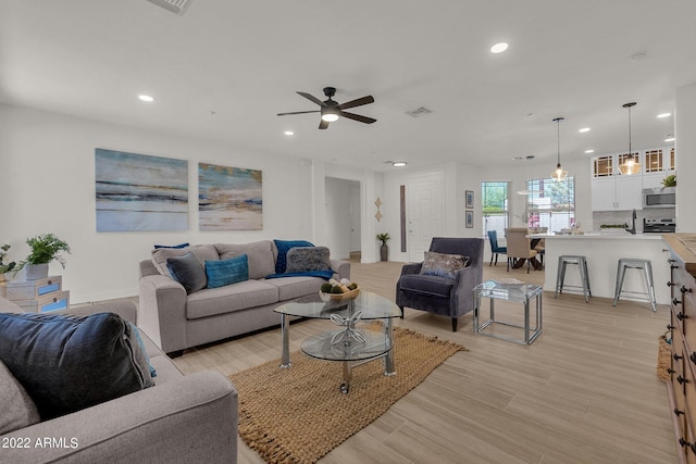 living room featuring ceiling fan and light hardwood / wood-style floors