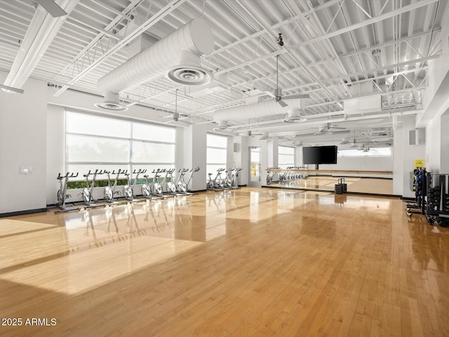 workout area featuring ceiling fan, visible vents, baseboards, and hardwood / wood-style floors