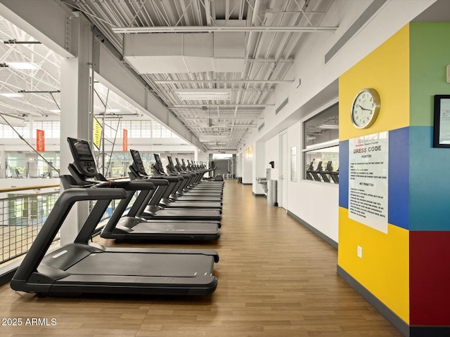 workout area with baseboards and wood finished floors