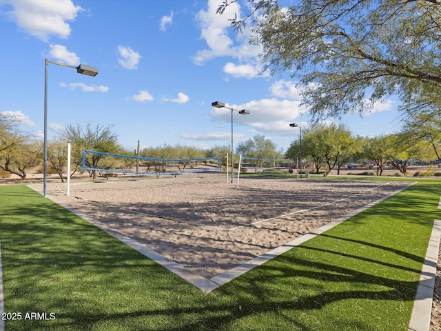 view of community with volleyball court and a lawn