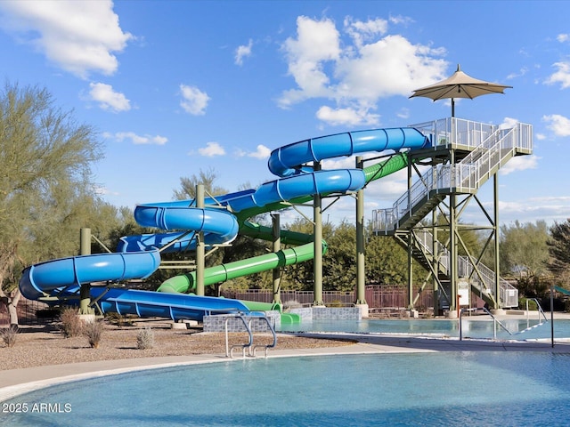 view of pool with playground community and fence