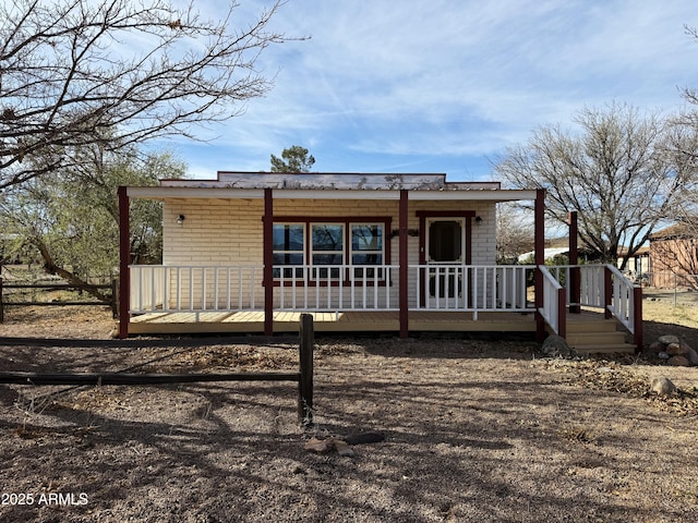 view of front of home with a porch and brick siding