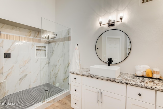 18818 N 95th Ave, Peoria, AZ 85382 - full bathroom with vanity, a marble finish shower, visible vents, a notable chandelier, and wood finished floors